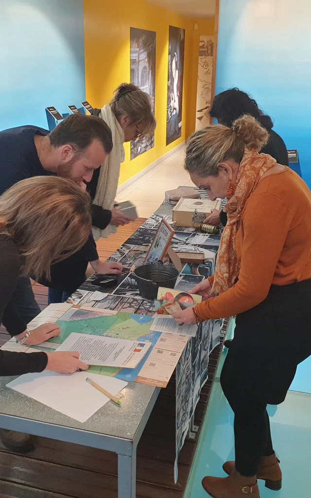 Groupe de personnes debout autour de la table en train d'essayer de résoudre les énigmes