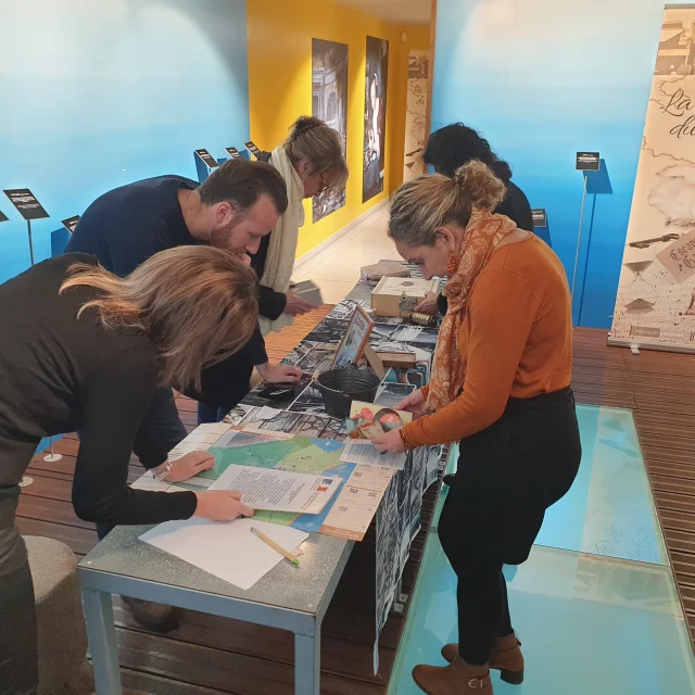 Groupe de personnes debout autour de la table en train d'essayer de résoudre les énigmes