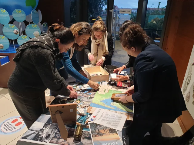 Groupe de personnes debout autour de la table en train d'essayer de résoudre les énigmes