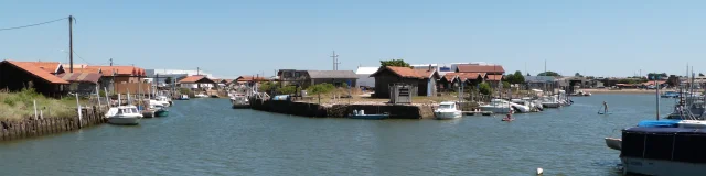 Photo du port de Larros où l'on voit la digue ouest avec quelques cabanes