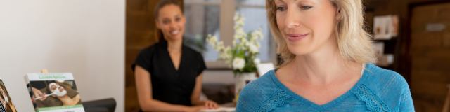 Une conseillère en séjour qui vient de donner une brochure à une cliente qui est en train de la feuilleter