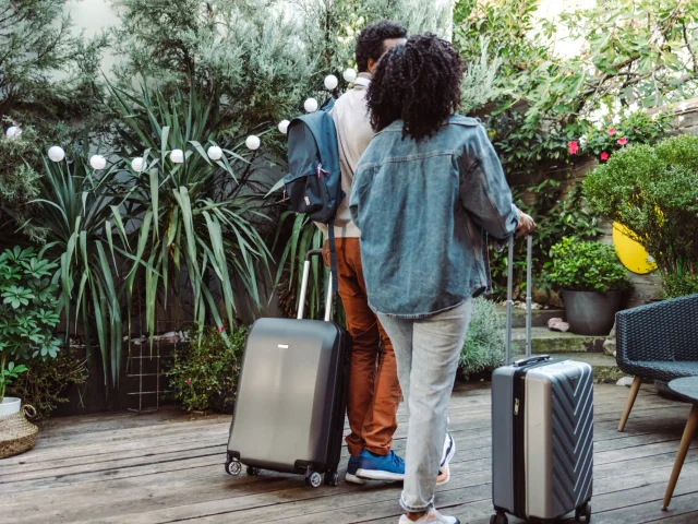 Couple avec valises arrivant dans un hébergement touristique