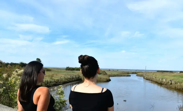 Deux femmes qui discutent assise sur un muret devant le Bassin au Port de la Mole à Gujan-Mestras