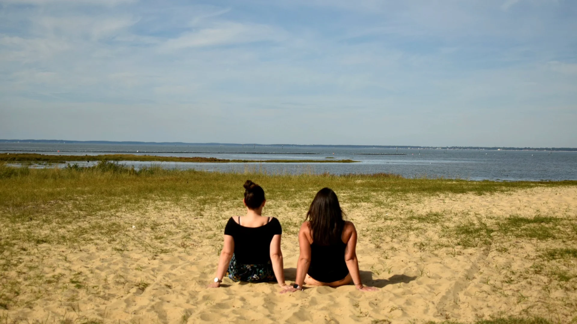 Deux femmes qui discutent assise sur le sable devant le Bassin à Gujan-Mestras
